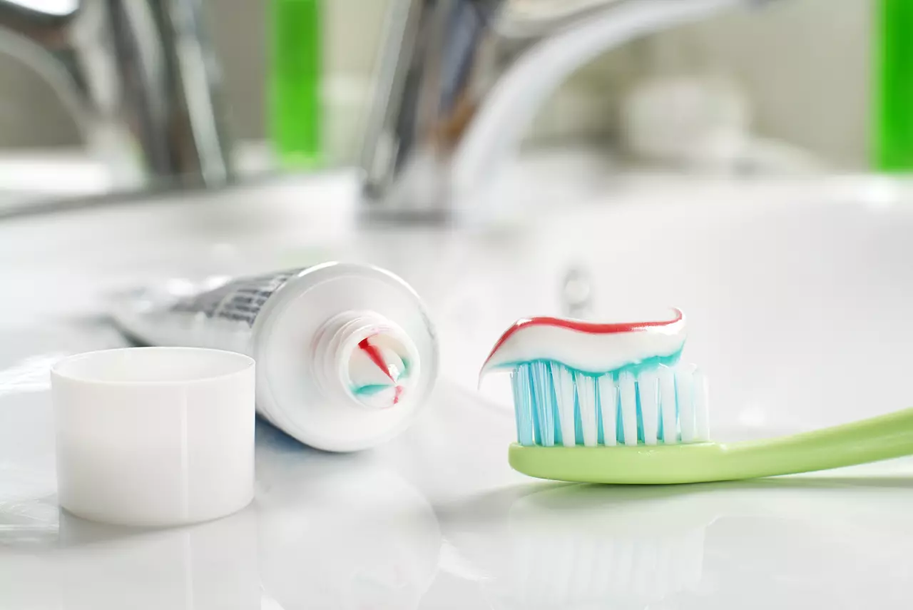 Toothbrush and toothpaste in the bathroom closeup.